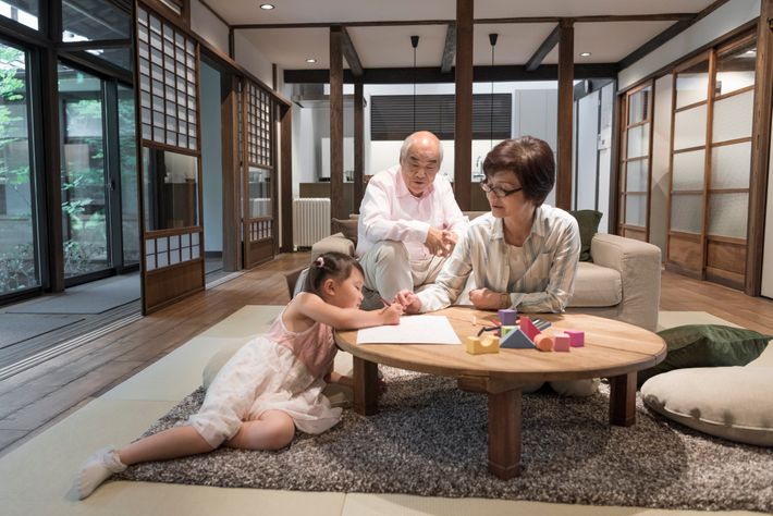 祖父母に見守られながら絵を描く女の子