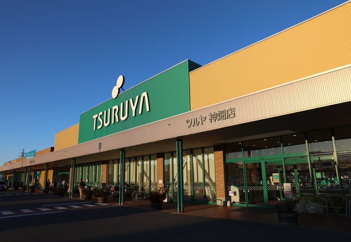 食料品や生活用品が揃うスーパーマーケットのツルヤ神畑店の外観写真。
