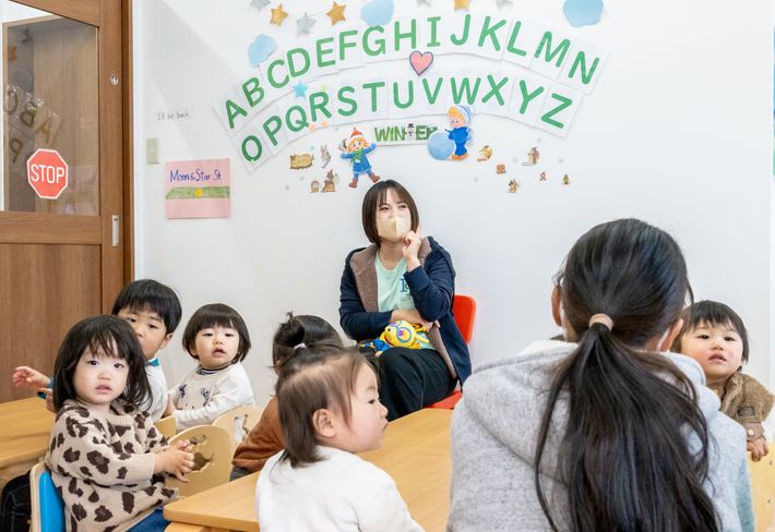 保育園留学で地元の園児と一緒に保育園の先生の話を聞く子どもの写真