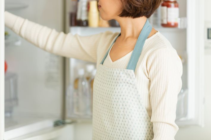 冷蔵庫から何かを取り出す女性