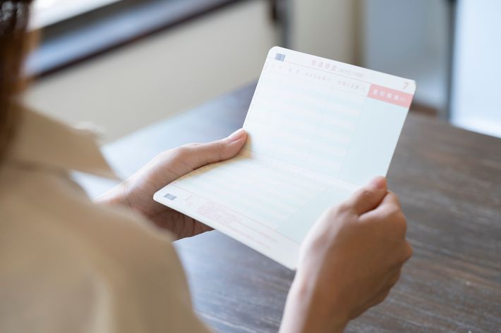 女性が通帳を両手で持っている