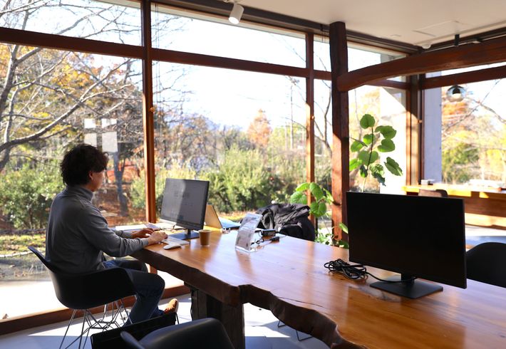 子どもが保育園にいる間に自然に囲まれた開放的な空間で仕事をする筆者の写真です。