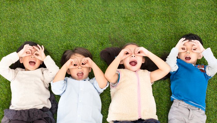 幸せな男の子と緑の草の上に横たわる女の子