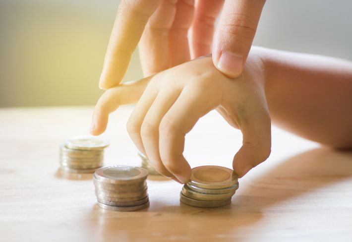 コインを持つ親子の手