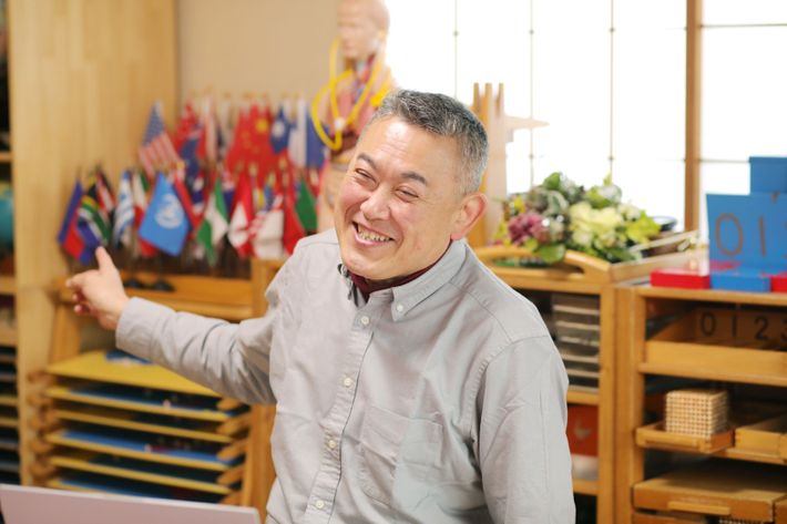 教具をバックにお話する百枝先生